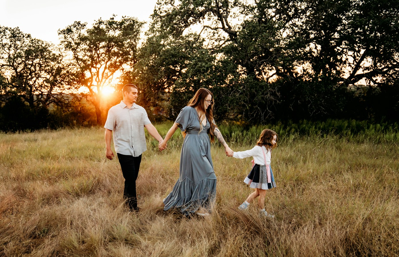 Family holding hands during a golden-hour walk
