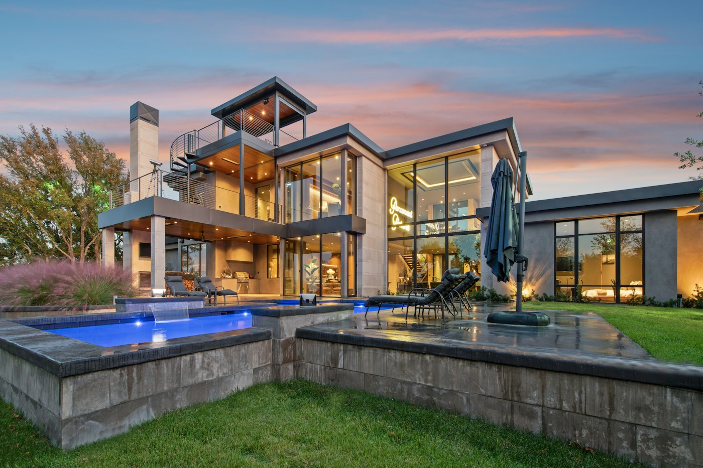Elegant modern home and pool illuminated at dusk